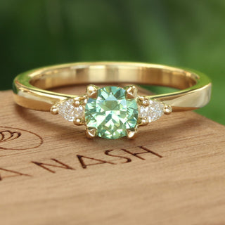 Green sapphire and pear cut diamond 18ct gold engagement ring  on wooden box