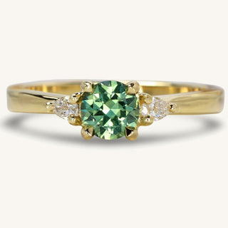 Green sapphire trilogy engagement ring made from 18ct gold with pear cut side diamonds
