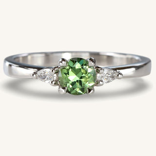 Handmade sustainable platinum trilogy engagement ring with a fair trade green sapphire and pear cut diamonds