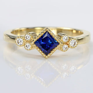 Handmade 18ct gold princess cut sapphire and diamond cluster ring with milgrain detail