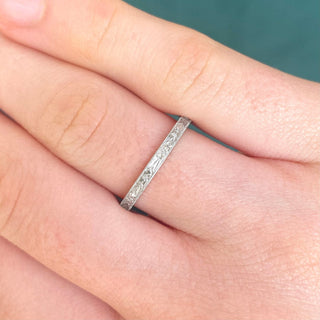 Platinum orange blossom engraved ring worn on a hand, showing its slim 2mm width and bright polish.