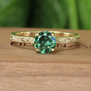 Deep green sapphire solitaire engagement ring, handmade from solid 18ct gold with hand engraved floral detail on the band.