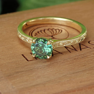 18ct gold solitaire ring with engraved detail set with a fair trade green sapphire