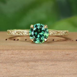 18ct gold green sapphire solitaire engagement ring with hand engraved orange blossom pattern