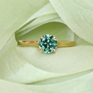 Parti sapphire solitaire ring on green ribbon backdrop