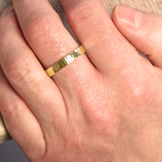18ct gold men's tree bark textured wedding band being worn on the hand