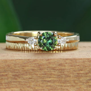 18ct gold green sapphire and pear cut diamond trilogy engagement ring with a slim tree bank textured wedding band