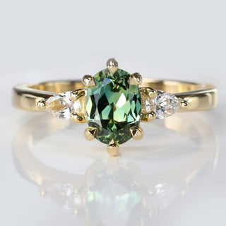 Green sapphire and pear cut diamond trilogy engagement ring in 18ct gold