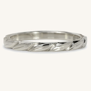 Sustainable 950 platinum slim wedding band with hand engraved leaves around the entire band