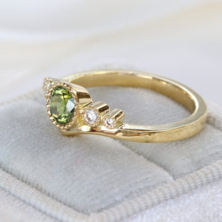 Handmade 18ct gold green sapphire and diamond wishbone engagement ring photographed at an angle.