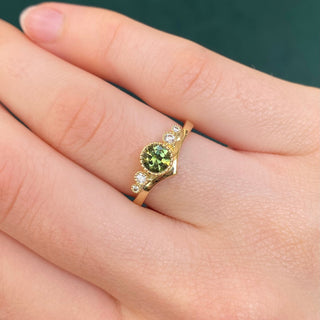 18ct gold green sapphire wishbone engagement ring shown worn on hand.