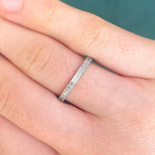 Platinum orange blossom engraved ring worn on a hand, showing its slim 2mm width and bright polish.