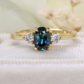 18ct gold Parti sapphire and diamond trilogy engagement ring styled with soft floral background.
