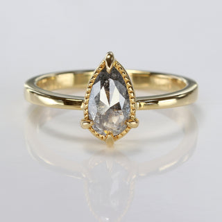 Pear cut salt and pepper diamond engagement ring in 18ct gold on soft cream background.