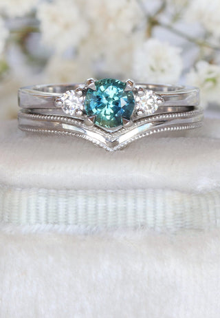 platinum bridal set with teal sapphire and diamond trilogy ring and wishbone wedding ring with engraved border