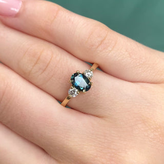 Parti sapphire trilogy engagement ring in 18ct gold shown worn on hand.