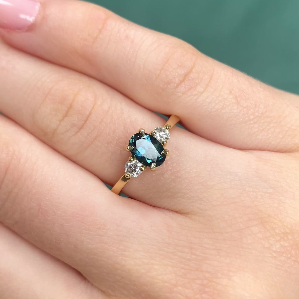 Parti sapphire trilogy engagement ring in 18ct gold shown worn on hand.