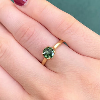 Parti sapphire solitaire engagement ring shown worn on hand.