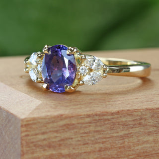 Roseland purple sapphire engagement ring with diamonds - angled photo on wooden ring box, green background