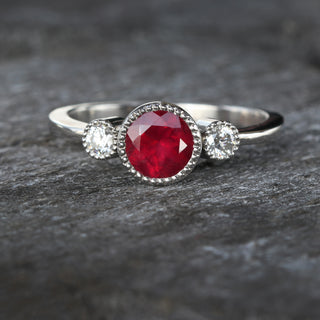 Ruby and diamond ring photographed on textured background