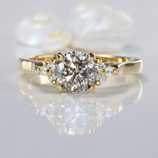 Salt and pepper diamond cluster 18ct gold engagement ring on reflective surface.