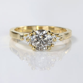 Handmade 18ct gold salt and pepper diamond cluster engagement ring on reflective surface.