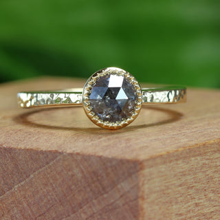 18ct gold salt and pepper diamond solitaire ring photographed outdoors on wooden surface.