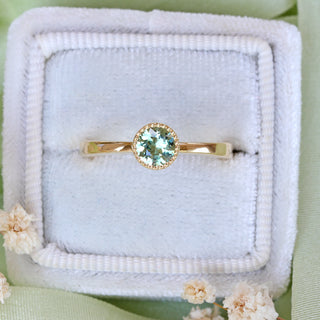 Green sapphire solitaire engagement ring in 18ct gold presented in a handmade wooden ring box.