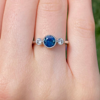 Platinum Parti sapphire and diamond trilogy engagement ring shown worn on hand.