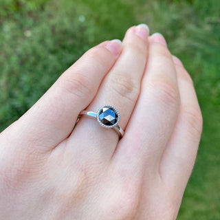 Hand shot of black diamond platinum solitaire engagement ring.