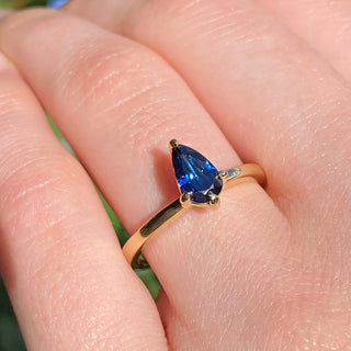 18ct gold blue sapphire solitaire engagement ring worn on the hand.