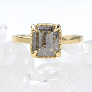 Close up of emerald cut salt and pepper diamond solitaire ring
