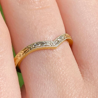 Close up of gold textured wishbone ring on finger showing orange blossom detail