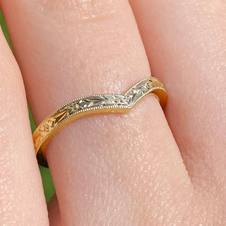 Close up of gold textured wishbone ring on finger showing orange blossom detail