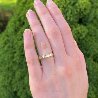 Diamond wedding or eternity band, handmade from sustainable 18ct gold. Being worn on the hand