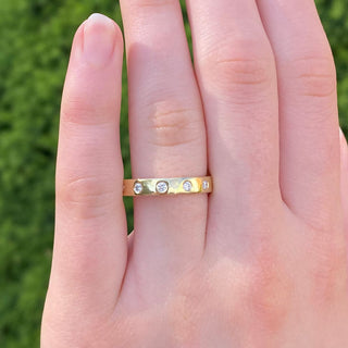 Diamond eternity or wedding band, made in Cornwall from solid 18ct gold. Being worn on the hand