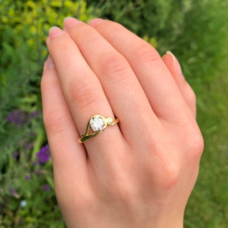 18ct gold icy diamond Art Nouveau engagement ring shown worn outdoors.