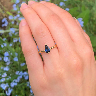 Hand shot of blue sapphire solitaire engagement ring in 18ct gold.