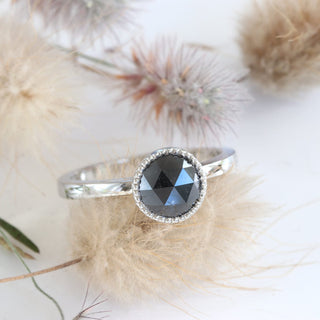 Angled view of platinum black diamond engagement ring with seed heads