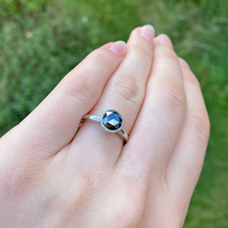 Hand shot of black diamond platinum solitaire engagement ring.
