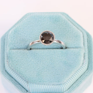 Handmade platinum black diamond engagement ring displayed in pale blue ring box.