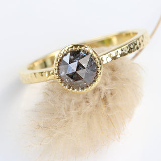 Close up of rose cut salt and pepper solitaire ring with hammered finish on seedhead.