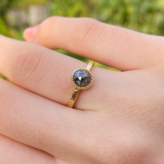 Salt and pepper diamond ring shown worn on hand in natural light.
