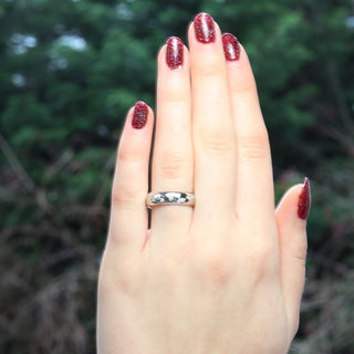6mm wide platinum hammered wedding ring, set with a scattering of natural diamonds. Being worn on the hand