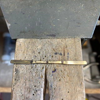 Handmade sapphire and diamond cluster engagement ring in progress at jeweller’s bench.