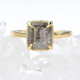 Close up of emerald cut salt and pepper diamond solitaire ring