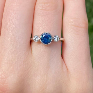 Platinum Parti sapphire and diamond trilogy engagement ring shown worn on hand.