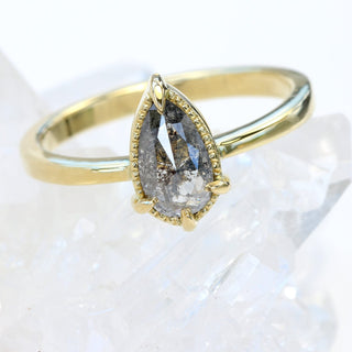 Angled view of bezel set pear cut salt and pepper diamond ring.