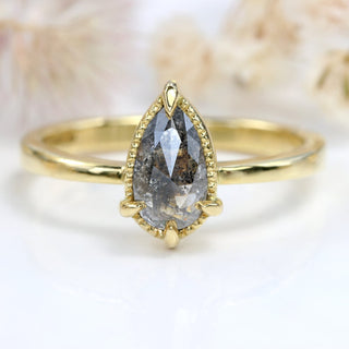 Pear cut rose cut salt and pepper diamond ring photographed on pale floral background.