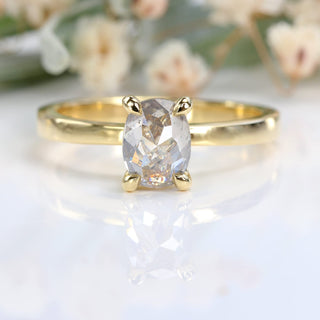 Front view of oval salt and pepper diamond solitaire engagement ring, floral background.